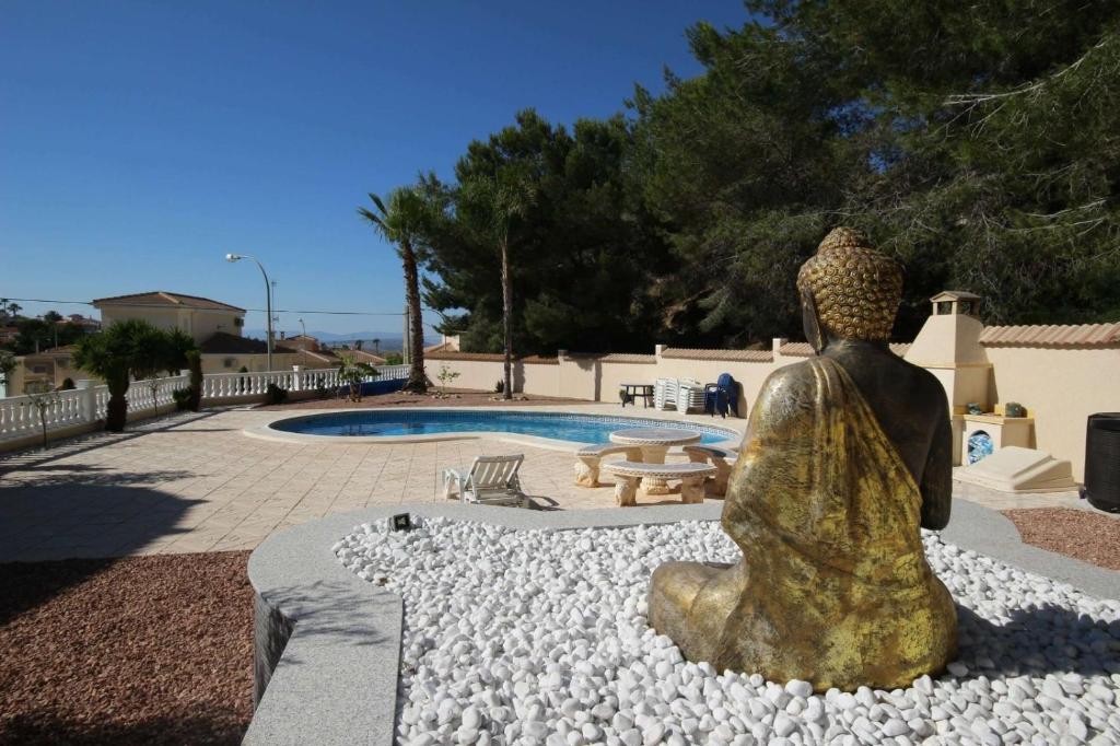 una estatua de una mujer sentada frente a una piscina en Preciosa Villa con Piscina particular, en San Miguel de Salinas