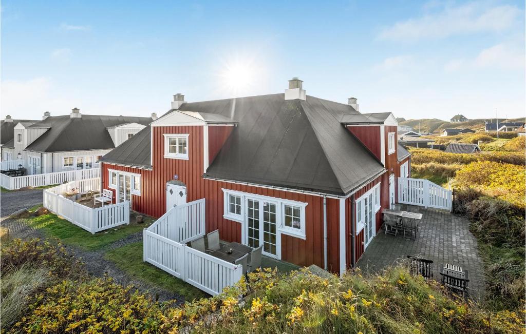 una casa roja con techo negro en Beautiful Apartment In Ringkbing With Sauna, en Søndervig