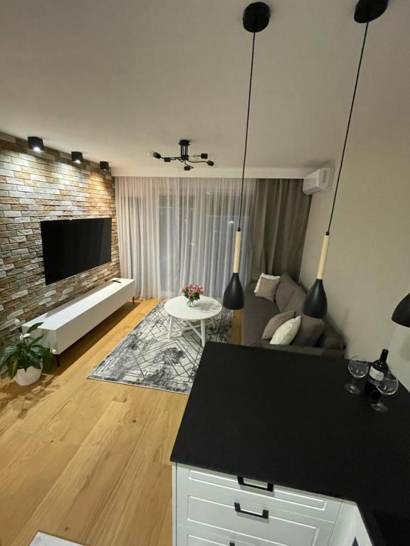 a living room with a couch and a tv at Księżycowy Apartament Ursus in Warsaw