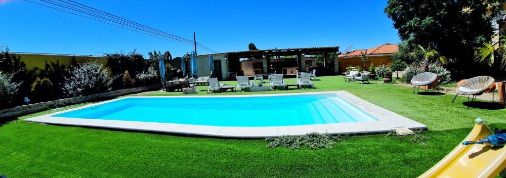 una piscina en medio de un patio en Casa Rural La Piedra De Juana, en Malpartida de Cáceres