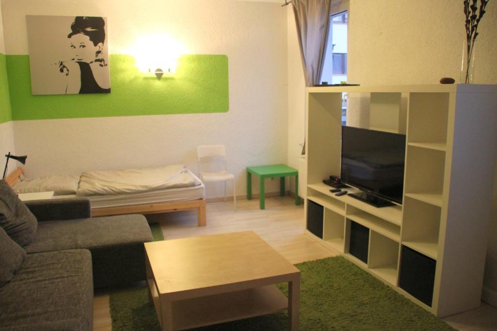 uma sala de estar com um sofá e uma televisão em FEWO Steile WH 2 Wand 106 Meerane em Meerane