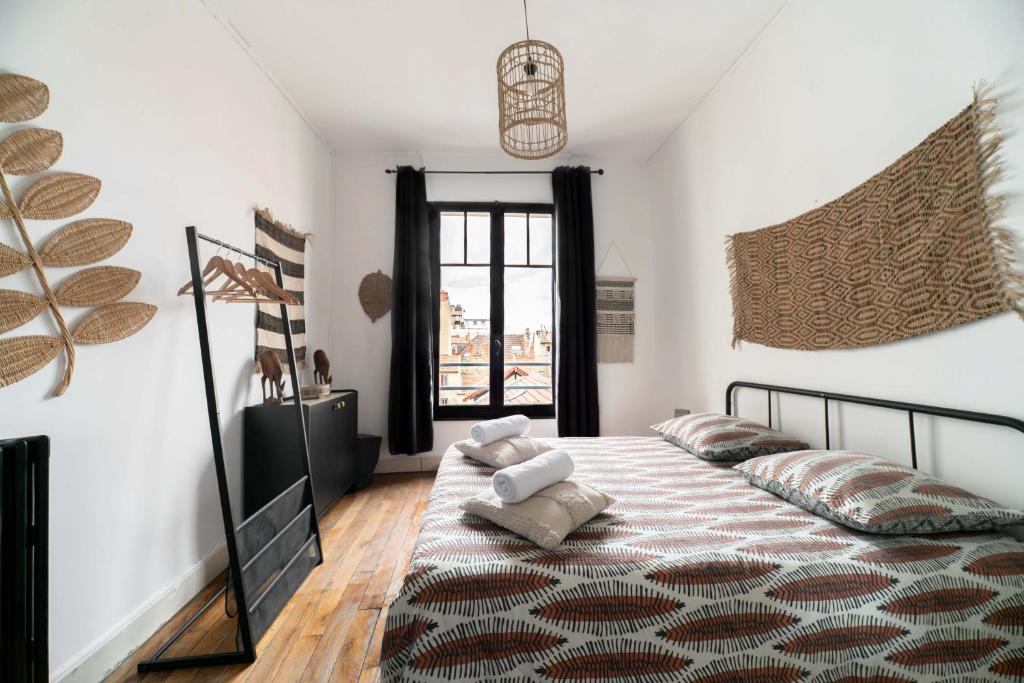 una camera da letto con un letto con cuscini sopra di Résidence Le Paris - Appartements centre ville a Vichy