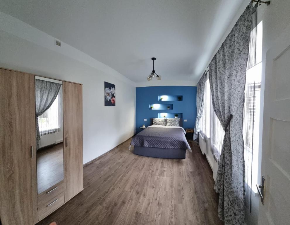 - une chambre avec un lit et un mur bleu dans l'établissement Cēsu mājas Rīgas ielā, à Cēsis