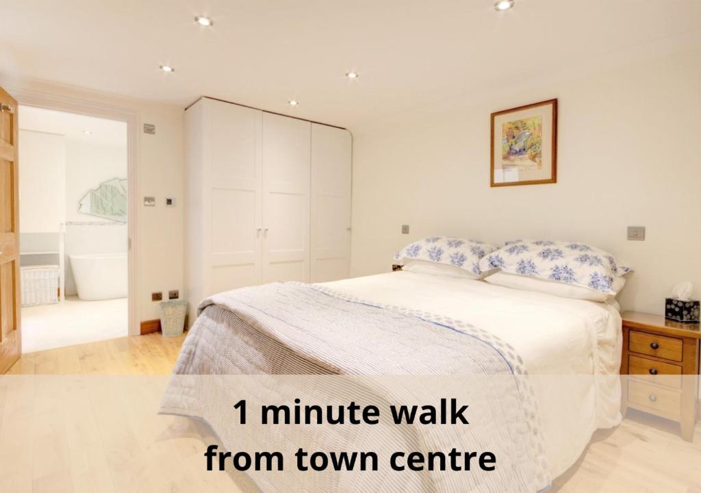 um quarto branco com uma cama e uma casa de banho em Luxury Apartments - 39 Rodney Road Apartment em Cheltenham