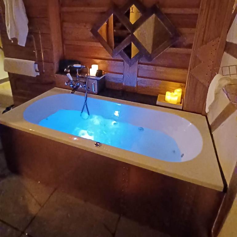 a jacuzzi tub in a bathroom with candles at La Cabane du Coing in Visé