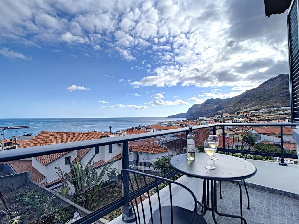 uma varanda com uma mesa e um copo de vinho em Casa da Avo by Atlantic Holiday em Caniçal