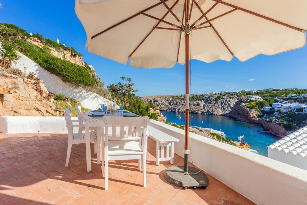 a patio with a table and an umbrella at Vacaciones en Cala Morell in Cala Morell