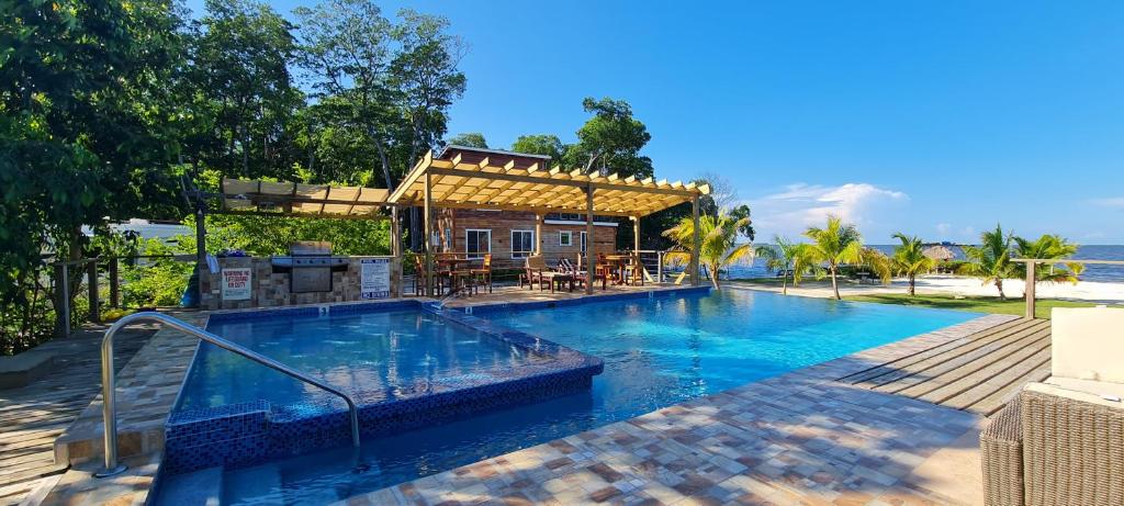 a swimming pool in front of a house at Seaside Chateau Resort in Belize City