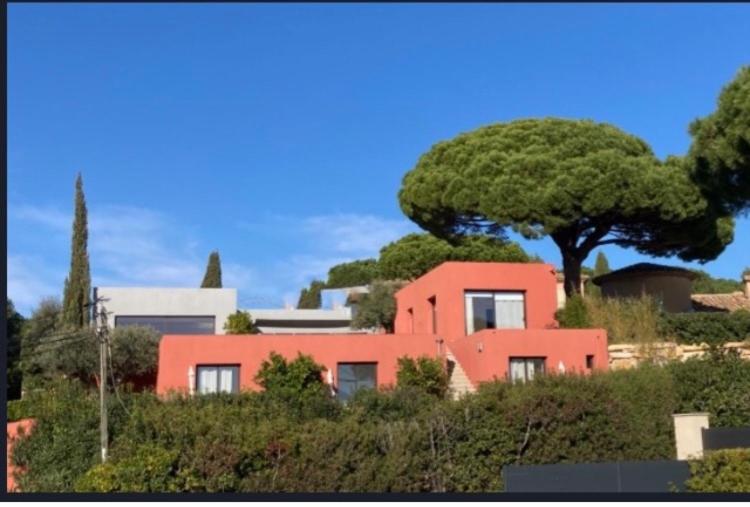 una casa in cima a una collina con un albero di Chambres d'hôtes VUE MER Mer à 2 min à pied a Sainte-Maxime