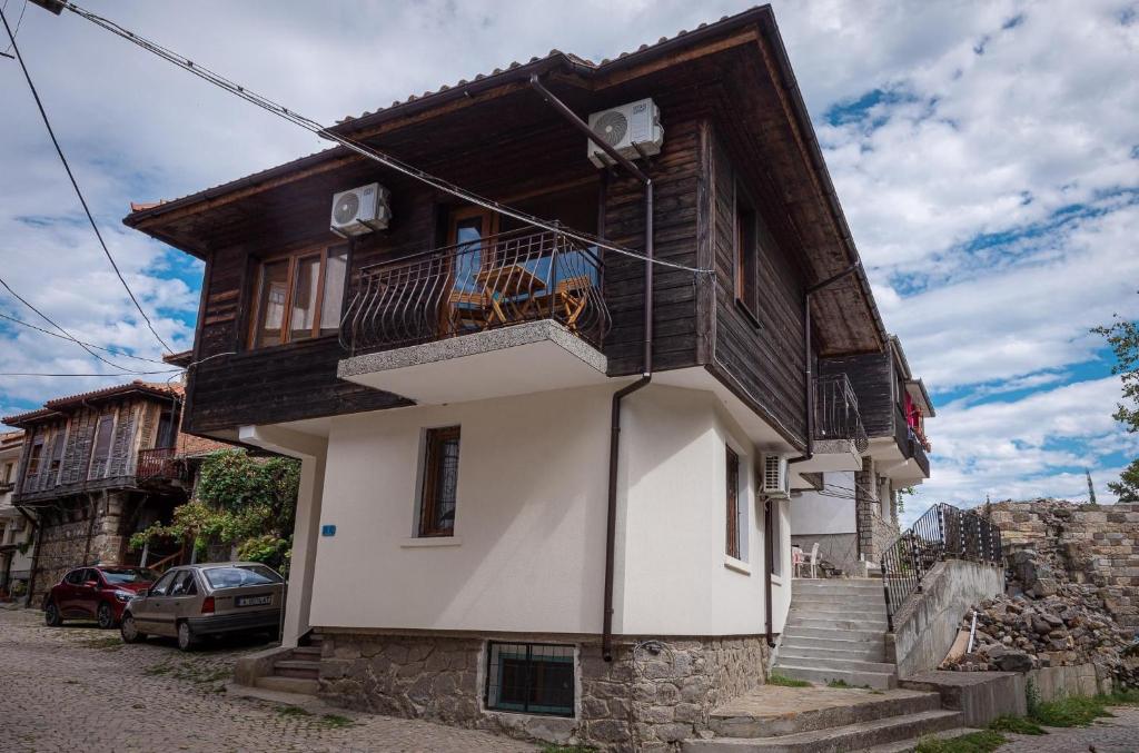 una casa con un balcón en el lateral. en Къща за гости Димови, en Sozopol