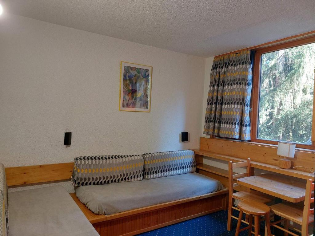 une chambre avec un canapé, une table et une fenêtre dans l'établissement Studio cosy pour 2, proche des pistes et commerces, au cœur des Arcs 1800 - FR-1-411-270, à Arc 1800