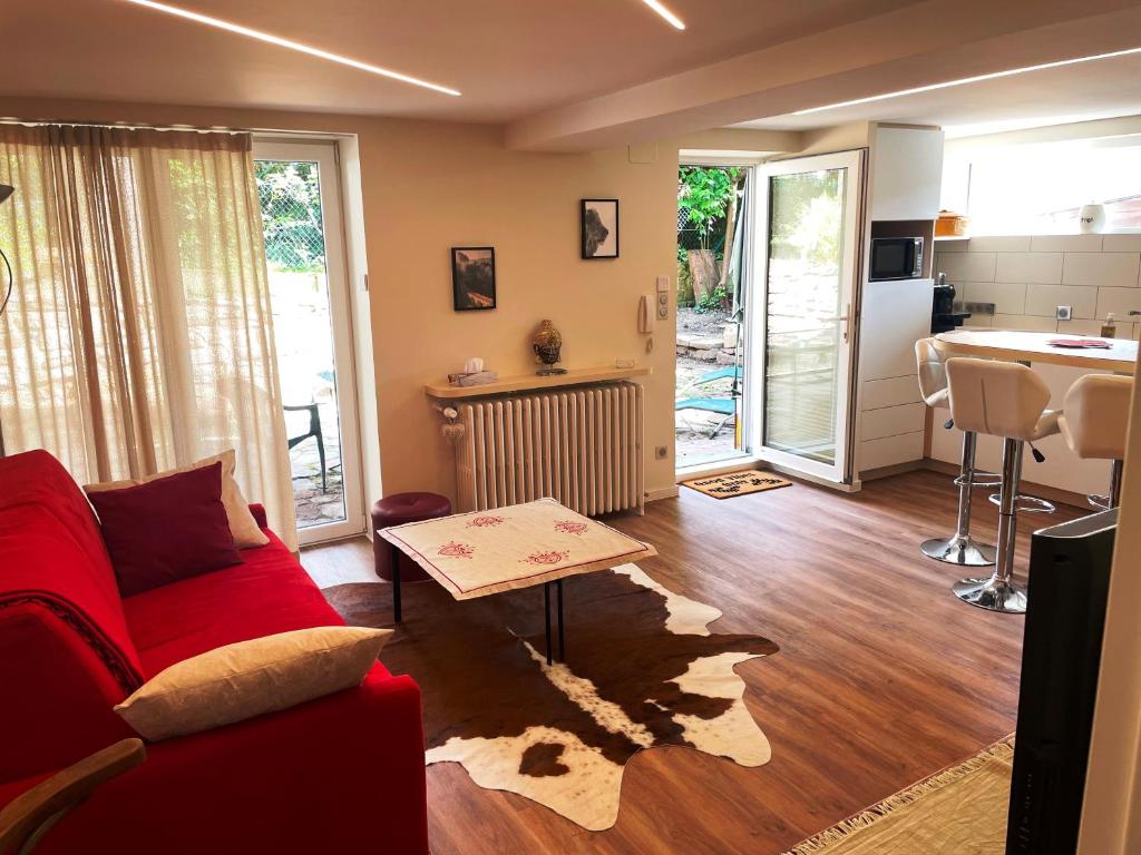 un salon avec un canapé rouge et une cuisine dans l'établissement appart privé dans villa meinau résidentiel, à Strasbourg