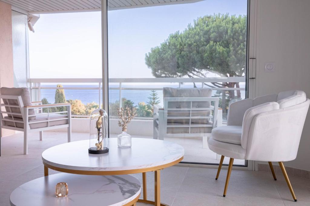 a living room with a table and chairs and a large window at Dream Apartment in Cannes
