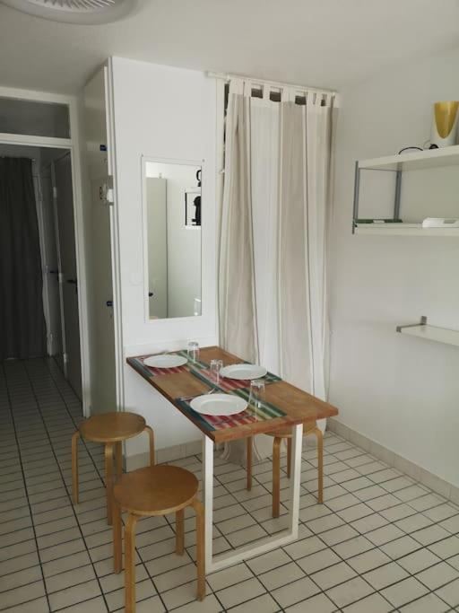 a table and two chairs in a room at Résidence arc en ciel, proche de la plage accés direct ,internet et parking privatif gratuit in La Grande Motte