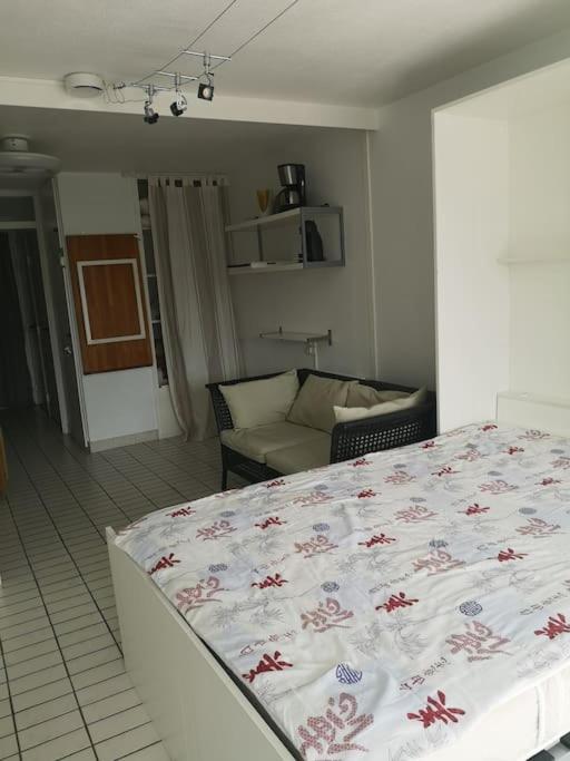 a bedroom with a bed and a couch at Résidence arc en ciel, proche de la plage accés direct ,internet et parking privatif gratuit in La Grande Motte