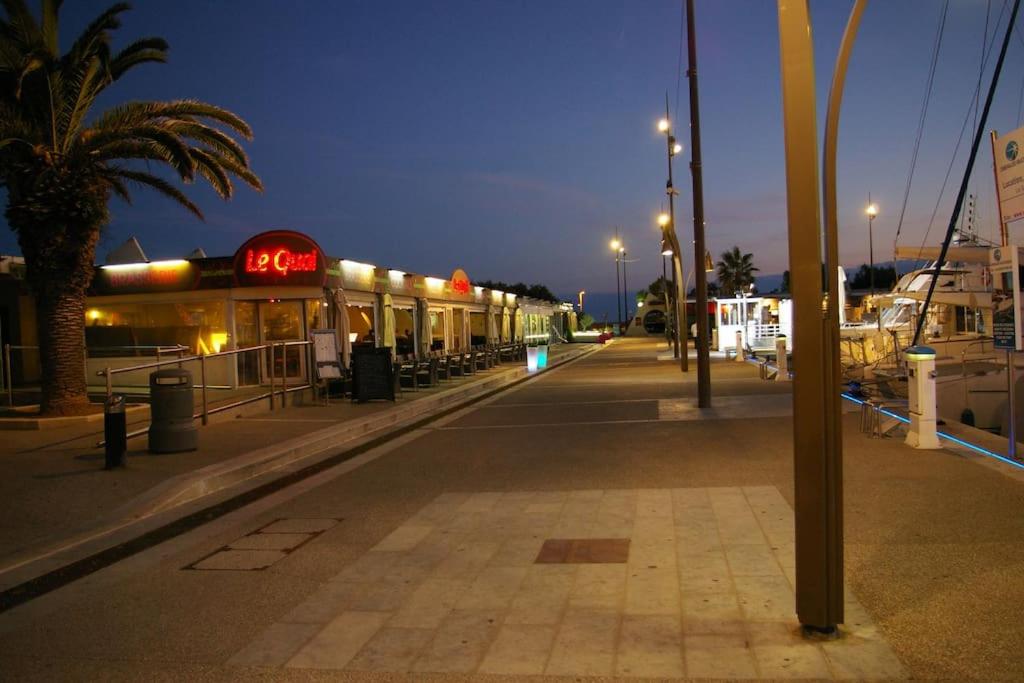 an empty street with a seafood restaurant at night at Résidence arc en ciel, proche de la plage accés direct ,internet et parking privatif gratuit in La Grande Motte
