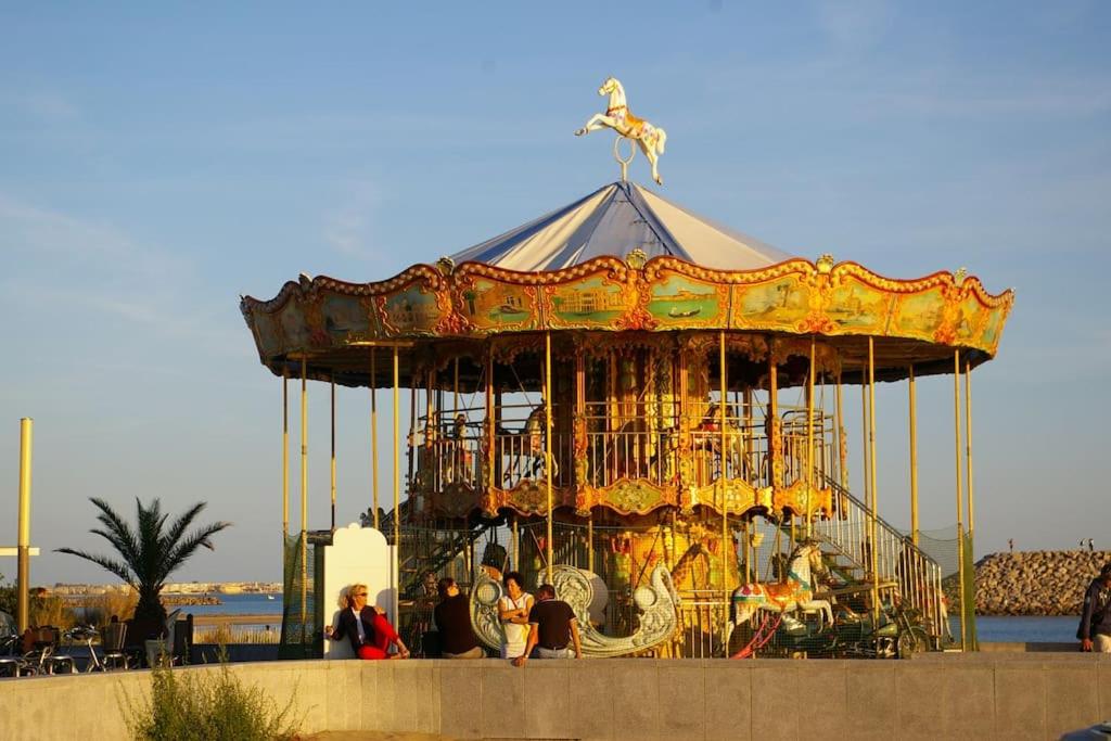 a group of people sitting on a carousel at Résidence arc en ciel, proche de la plage accés direct ,internet et parking privatif gratuit in La Grande Motte