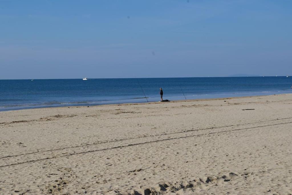a person standing on the beach looking at the ocean at Résidence arc en ciel, proche de la plage accés direct ,internet et parking privatif gratuit in La Grande Motte