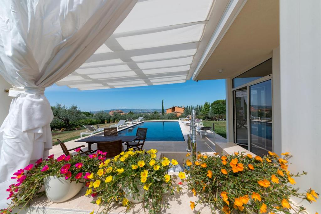 a patio with flowers and a swimming pool at GIULIVETO Bed and Breakfast in Foligno