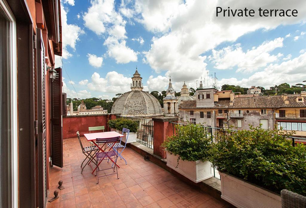 a balcony with a table and chairs on a balcony at Paradiso Penthouse - FromHometoRome in Rome