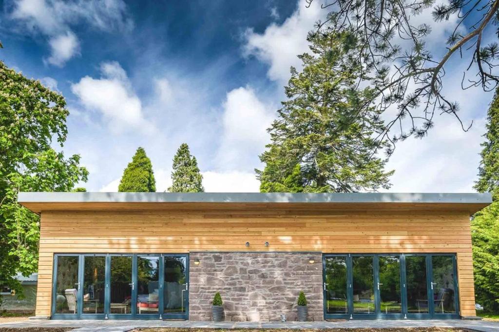 a house clad in wood with a flat roof at Garden Room Lodges in Alexandria