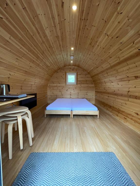 a bedroom with a bed in a wooden room at Eastridge Glamping - Camping Pods in Shrewsbury