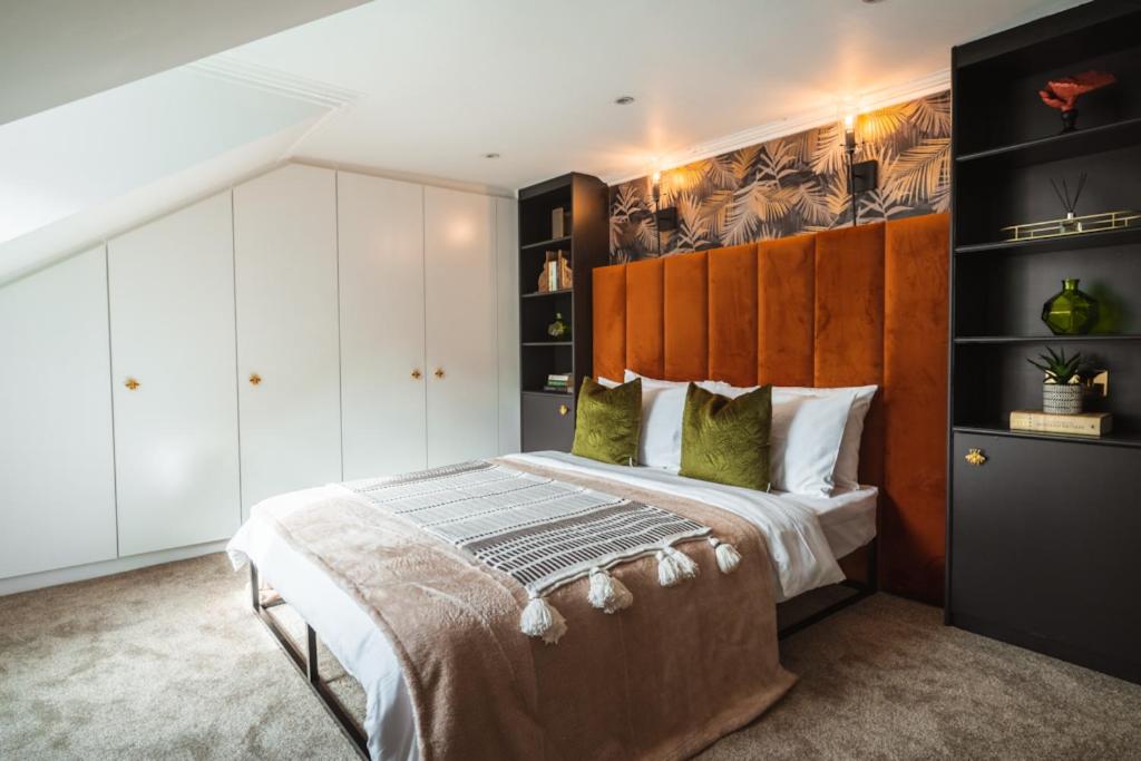 a bedroom with a large bed with a wooden headboard at The West End Loft - 5* Retreat - Private Parking! in Glasgow
