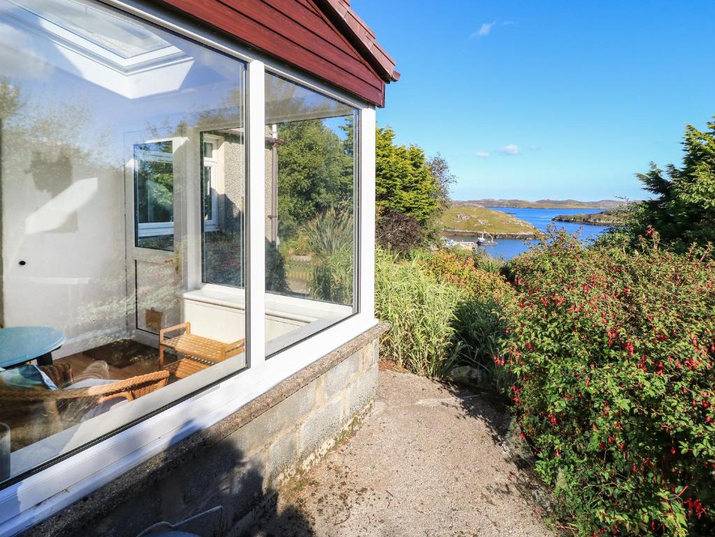 una ventana de una casa con vistas al agua en Beech Cottage, en Lochs