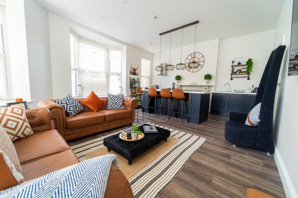 a living room with a couch and a kitchen at The Apartment - Brand new, stylish & central in Shanklin