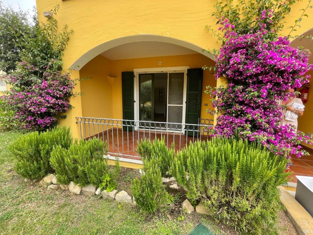 une maison avec des fleurs violettes à l'avant dans l'établissement Alloggio incantevole Costa Smeralda, à Porto Pozzo