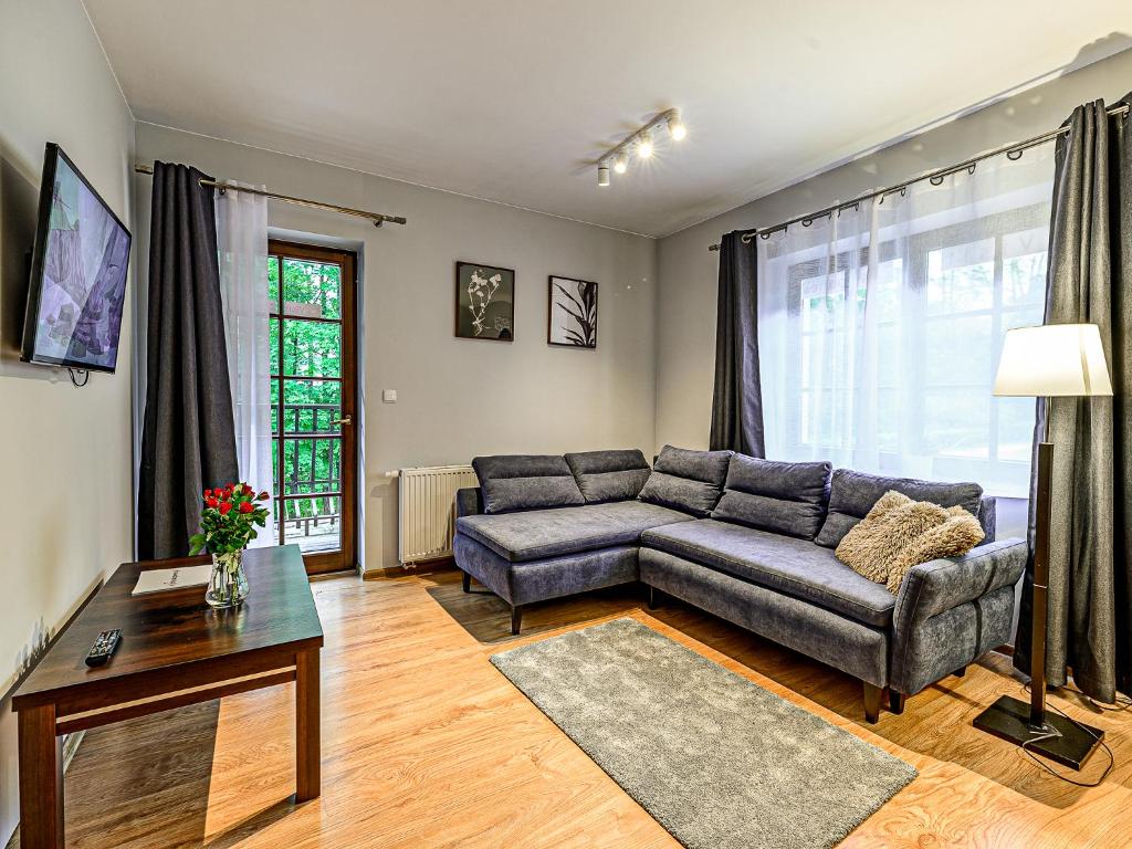 a living room with a couch and a table at VisitZakopane - Dubaj Apartment in Zakopane