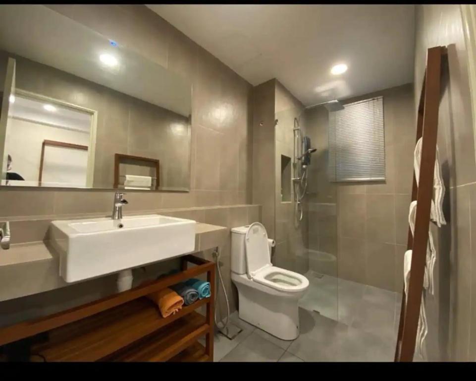 a bathroom with a sink and a toilet and a mirror at Timurbay Residence with Seaview 6pax 2Bedrooms Level 9 Kuantan in Kampung Sungai Karang