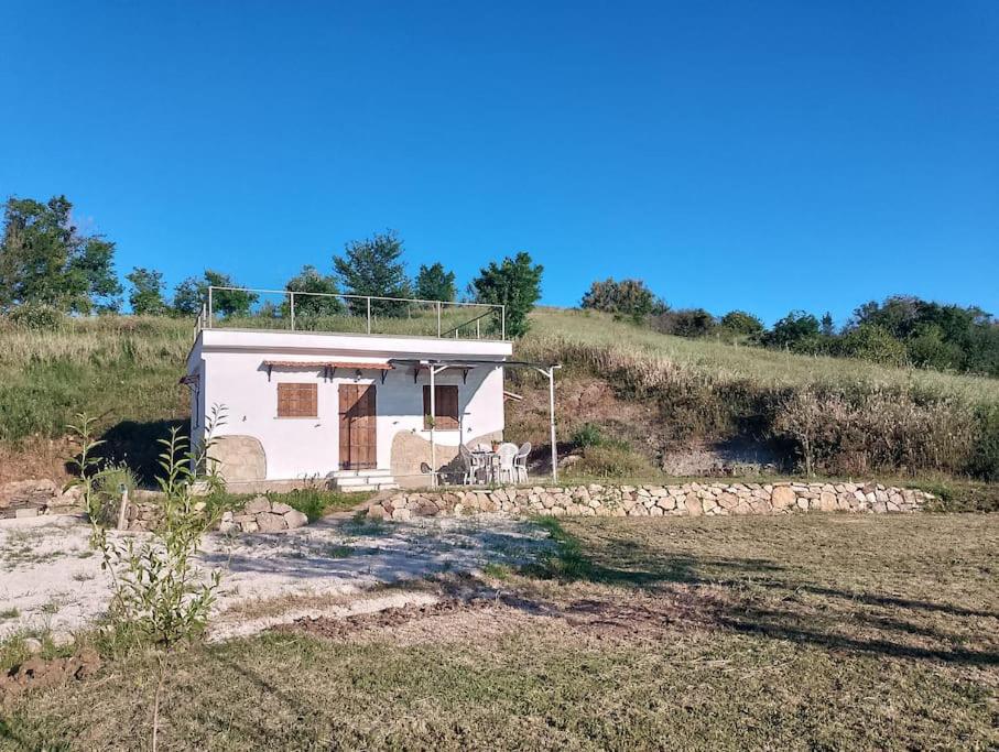 una pequeña casa blanca en una colina en un campo en Minicasa nella fattoria en Atessa