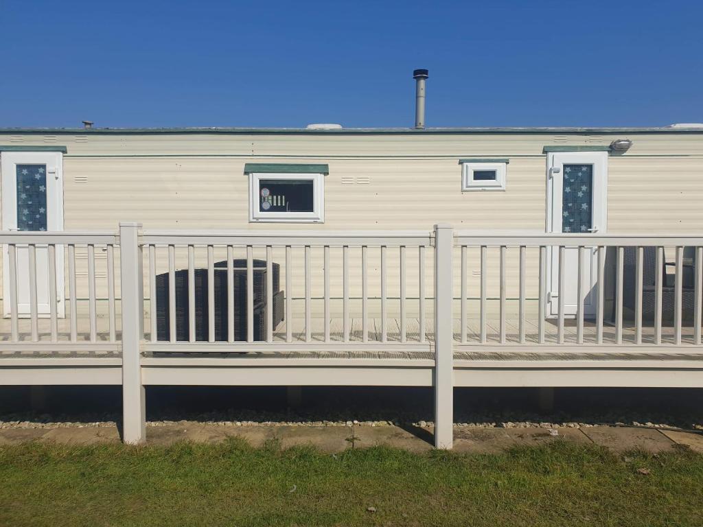 a white house with a fence in front of it at Caravan 2 coral beach Ingoldmells 6 berth in Ingoldmells