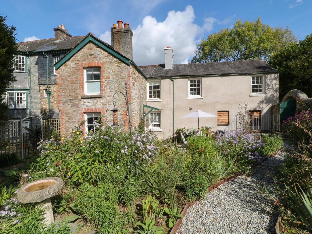 an old house with a garden in front of it at South Wing Cottage in Yelverton