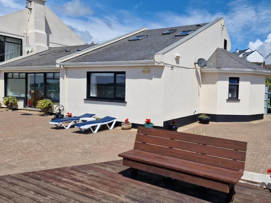 un edificio con un banco de madera delante de él en High Tide en Duncannon