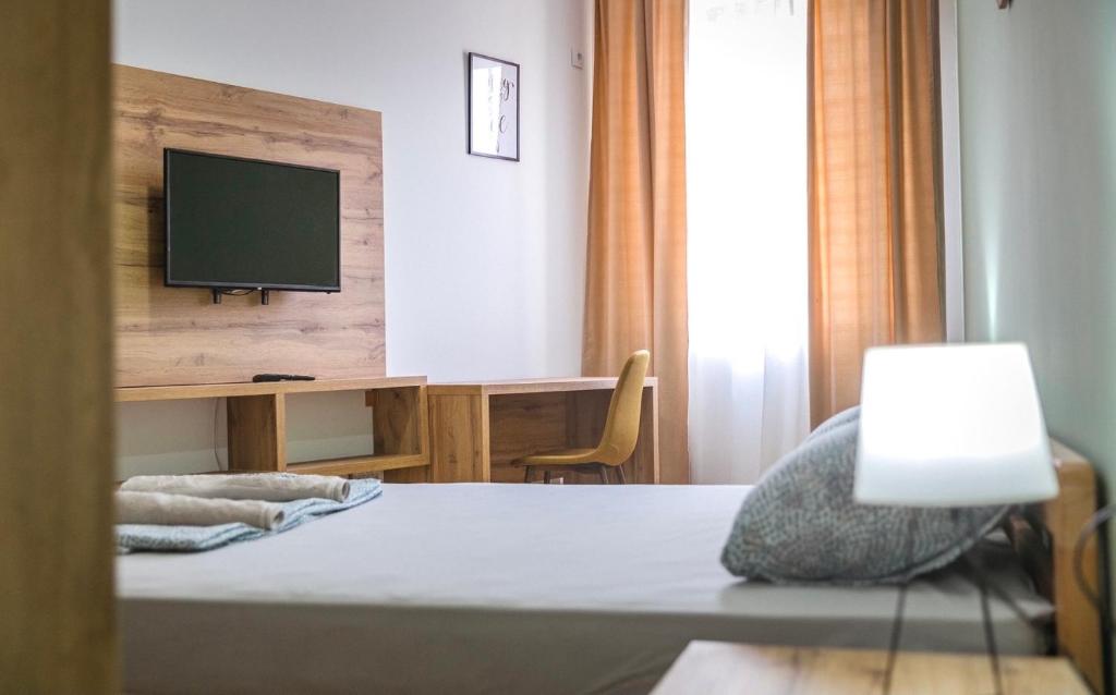 een slaapkamer met een bed en een televisie aan de muur bij Zoe Pirot in Pirot
