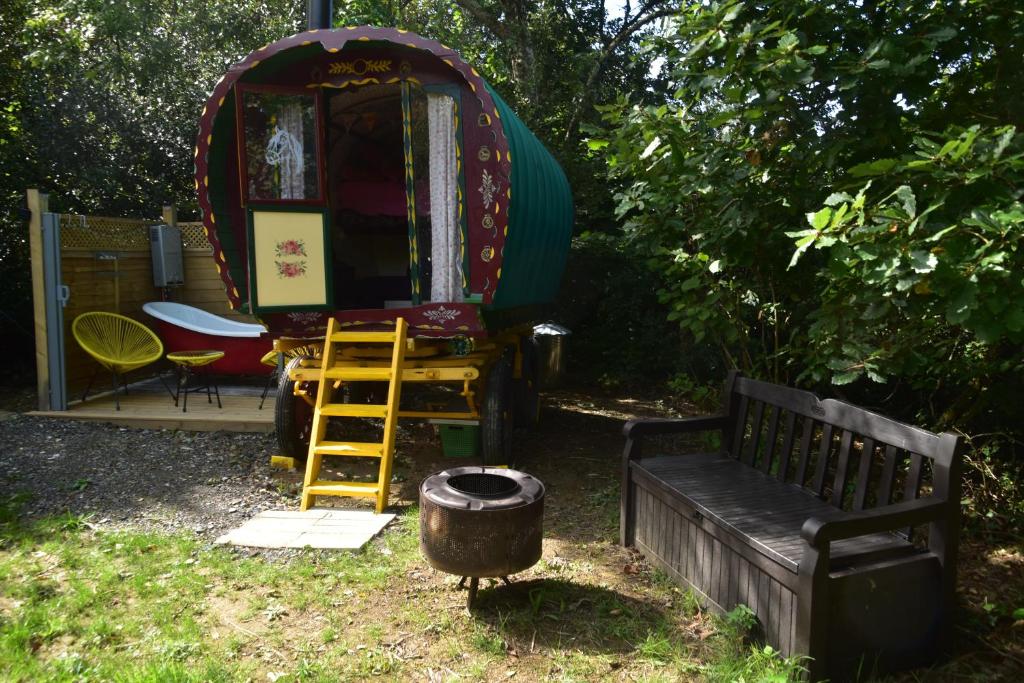 a small cabin with a bench and a barrel at Gypsy Sunrose in Bude
