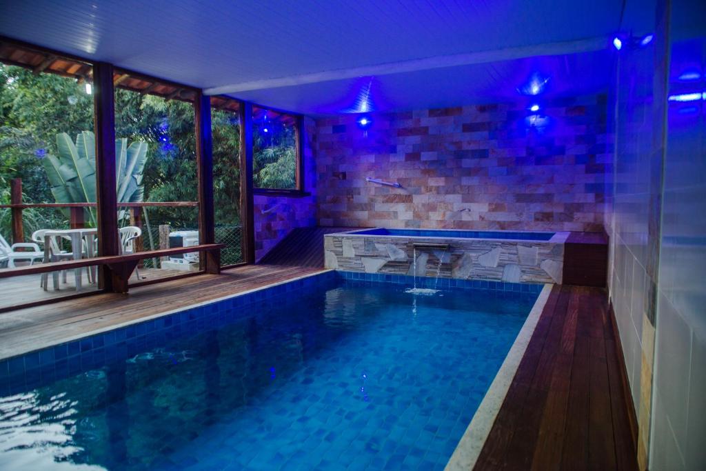 a swimming pool in a house with purple lights at Pousada Cipó Prata in Serra do Cipo