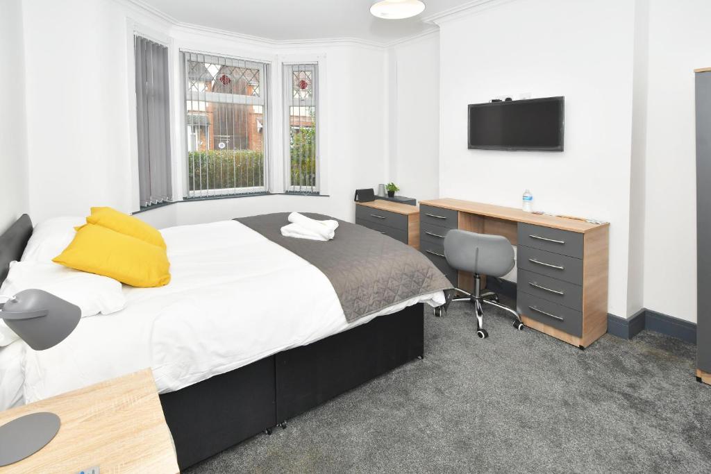 Schlafzimmer mit einem Bett, einem Schreibtisch und einem TV in der Unterkunft Townhouse @ Bedford Street Crewe in Crewe