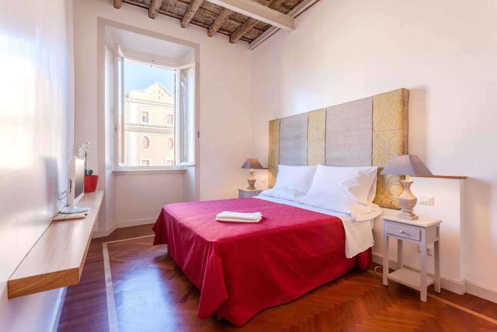 a bedroom with a bed with a red blanket and a window at The Bluehostel in Rome
