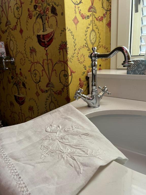 un asciugamano bianco seduto su un lavandino accanto a un rubinetto di Casa Fara a Fara San Martino