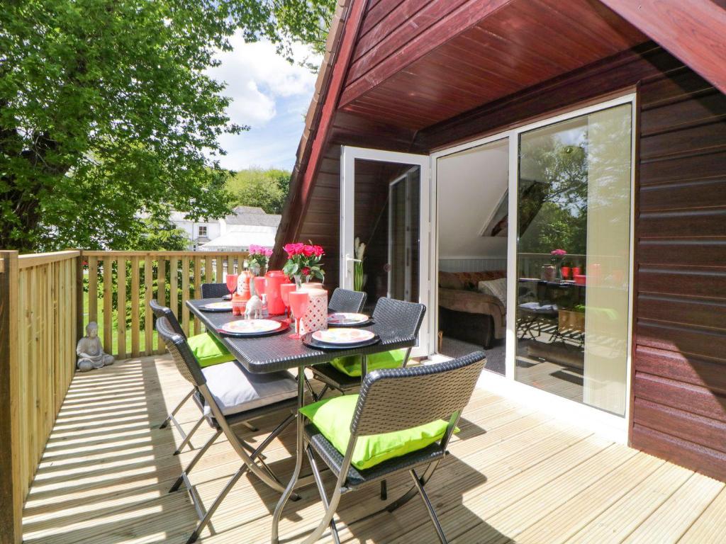 un patio con mesa y sillas en una terraza en 17 Valley Lodges, en Callington