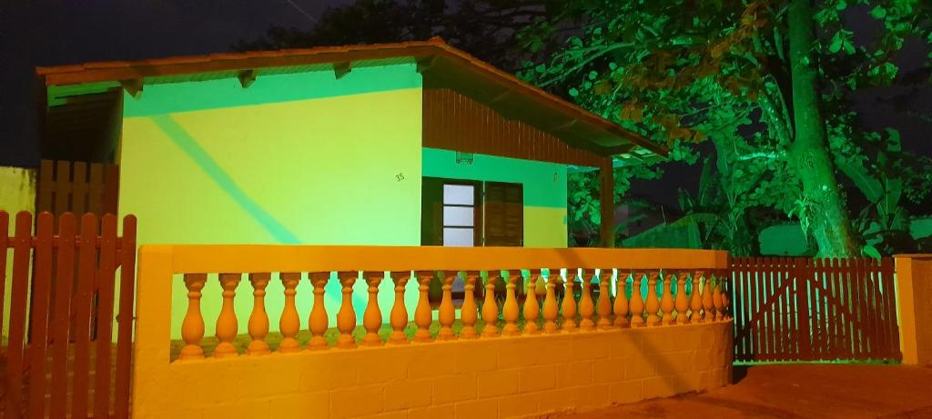 una pequeña casa con una valla delante de ella en Hostel 3.5, en Ubatuba