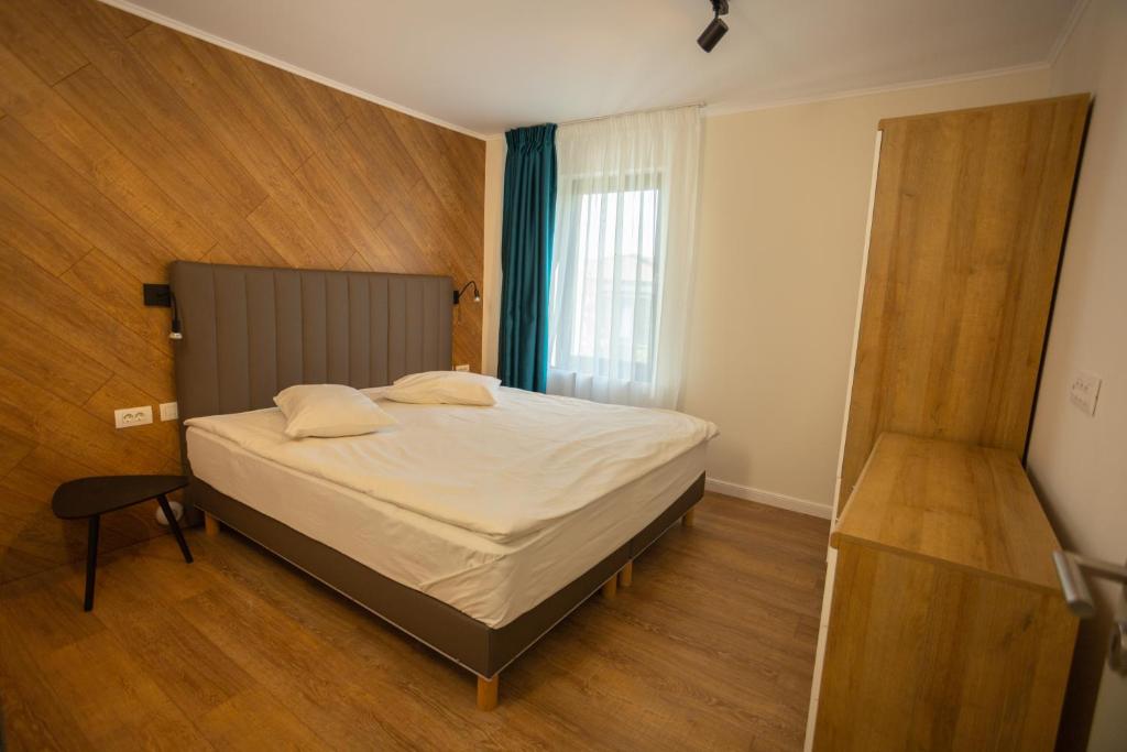 a bedroom with a bed and a window at Oliv Residence in Iaşi