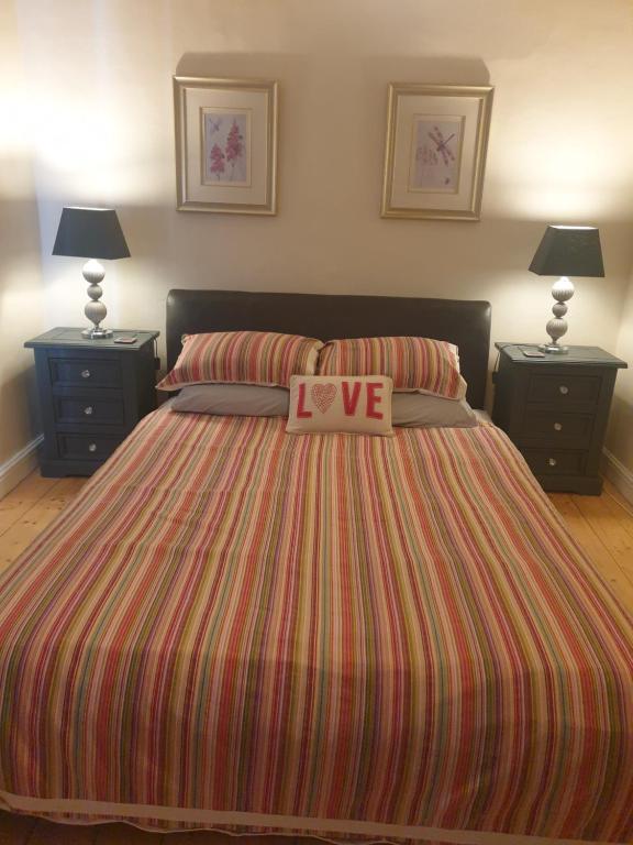 ein Schlafzimmer mit einem Bett mit Ich liebe Zeichen darauf in der Unterkunft Wildberry cottage in Orgères-la-Roche