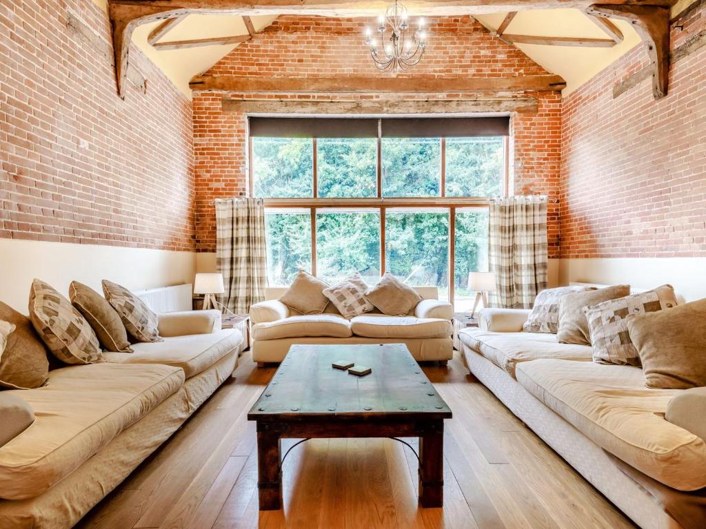 a living room with two couches and a table at High House Barn - Uk36929 in Foulsham