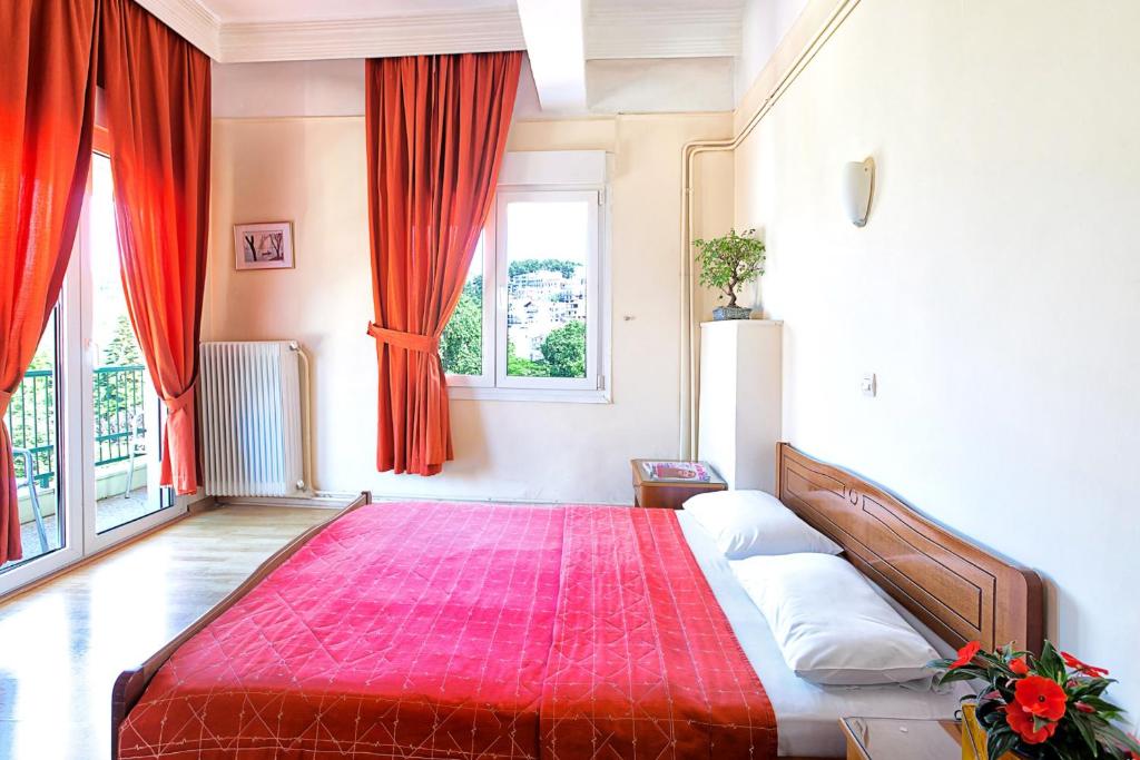 a bedroom with a large bed with a red blanket at Keletron Hotel in Kastoria