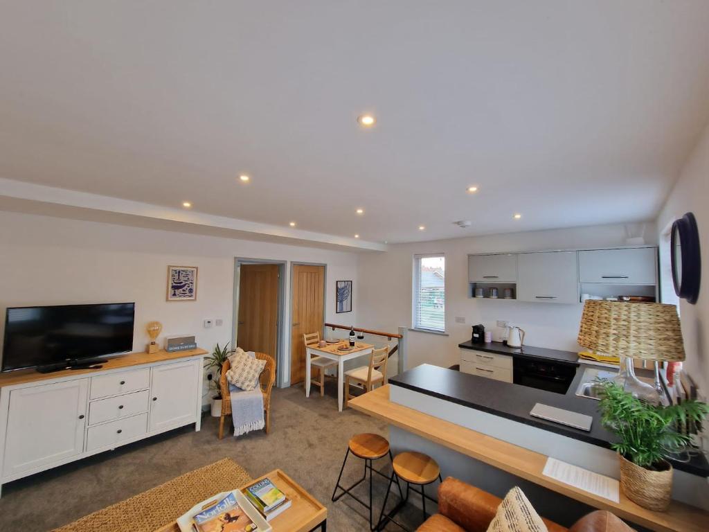 a living room with a kitchen and a dining room at The Crows Nest - Sheringham in Sheringham