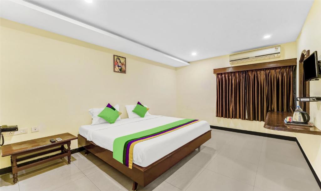 ein Schlafzimmer mit einem Bett und einem Tisch in einem Zimmer in der Unterkunft Treebo Trend B Coral 2 Km From Promenade Beach in Puducherry
